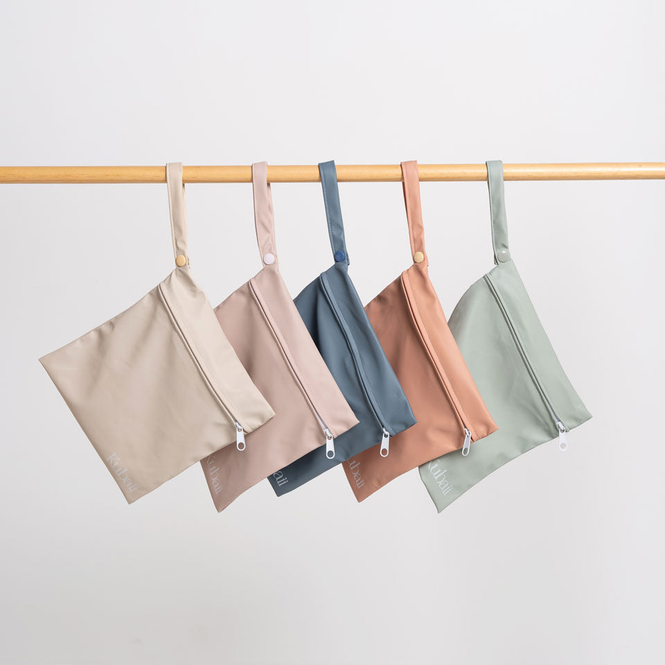 Kubaii waterproof baby bib packaged in a matching reusable wetbag for mess-free travel and storage.